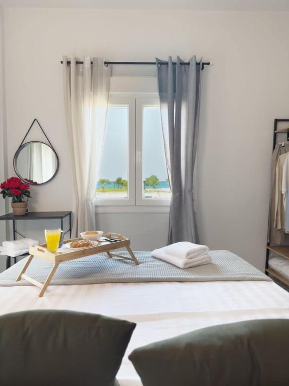 a bedroom with a bed with a table and a window at Blue Hotel Apartments in Ierissos