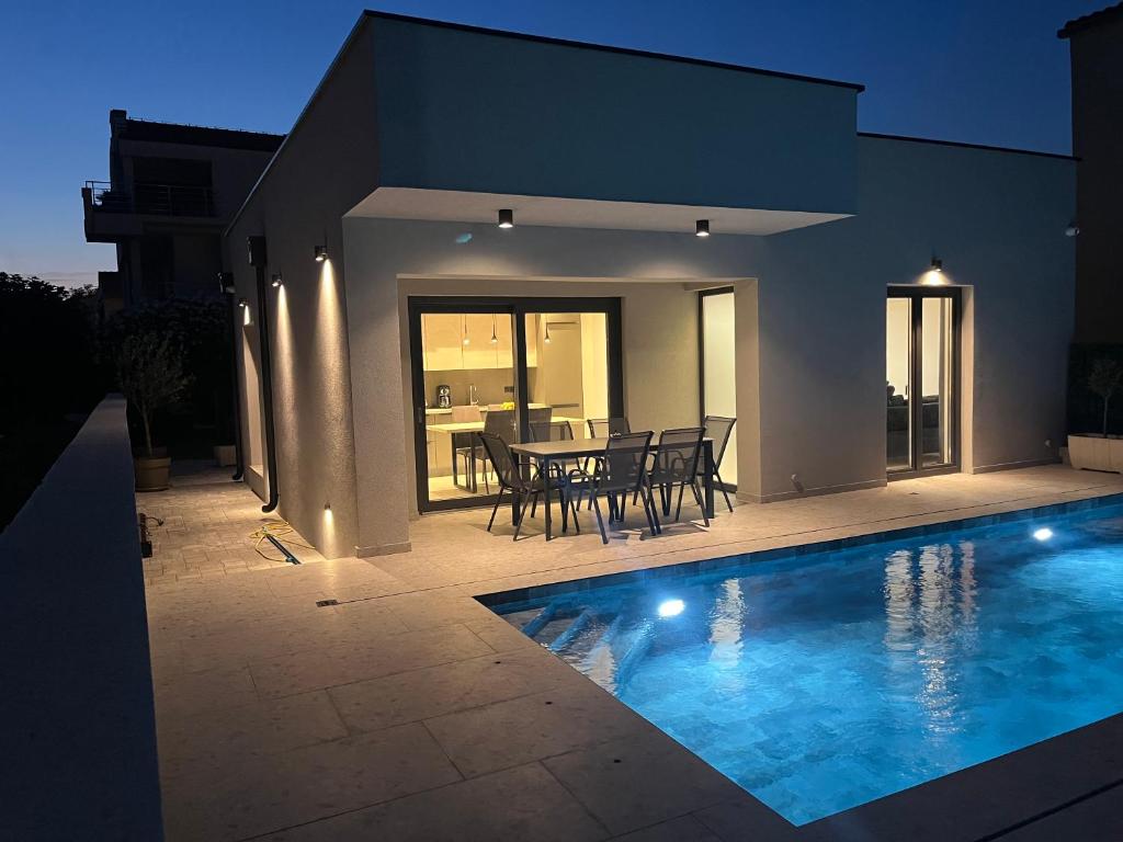 a house with a swimming pool in front of a house at Villa Matea pool house in Zadar