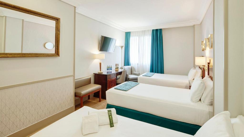 A bed or beds in a room at Sercotel Gran Hotel Conde Duque