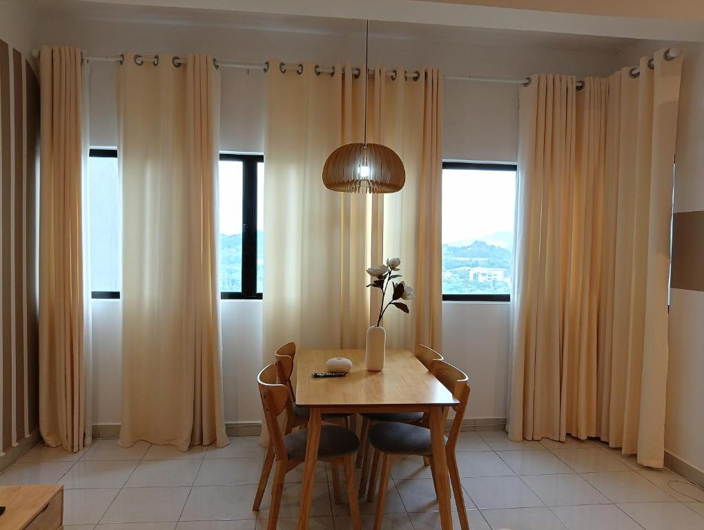 a dining room table with a lamp and two windows at Youth City Residence, Studio MUJI theme in Nilai