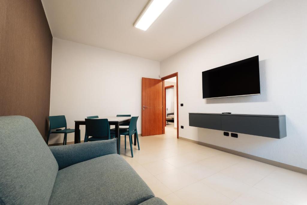 un soggiorno con un divano e una televisione su una parete di B&b Dante a Gravina in Puglia