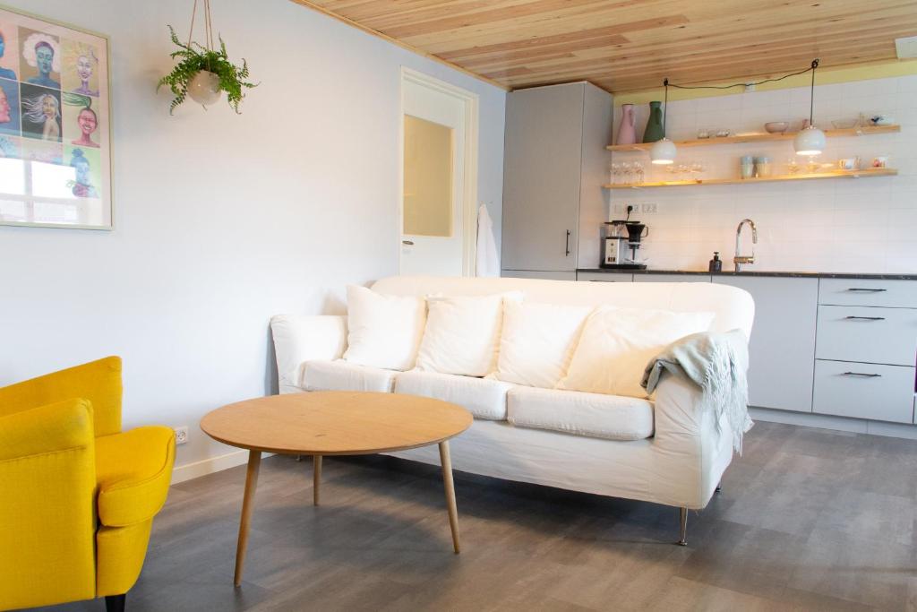 a living room with a white couch and a table at Colorful brand new apartment with free parking in Tórshavn