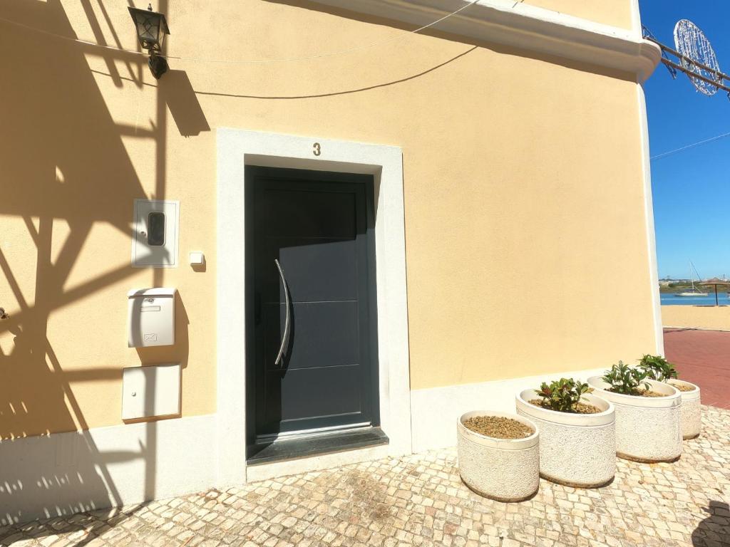 a black door on the side of a building at Almada, Seixal Beach House in Seixal