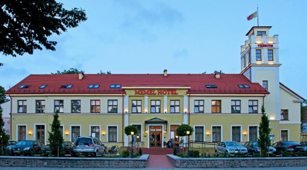 a building with a clock on the front of it at Memel Hotel in Klaipėda