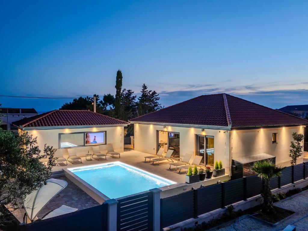 a villa with a swimming pool at night at Villa Ballat with heated pool in Privlaka