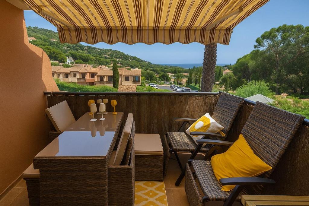 un patio avec une table et des chaises sur un balcon dans l'établissement Douceur Marine - T2 avec terrasse, parking, piscine et wifi, à Cavalaire-sur-Mer