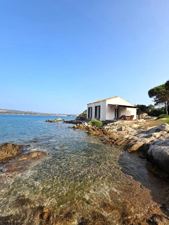 a house on the shore of a body of water at Blue Eden La Maddalena in La Maddalena