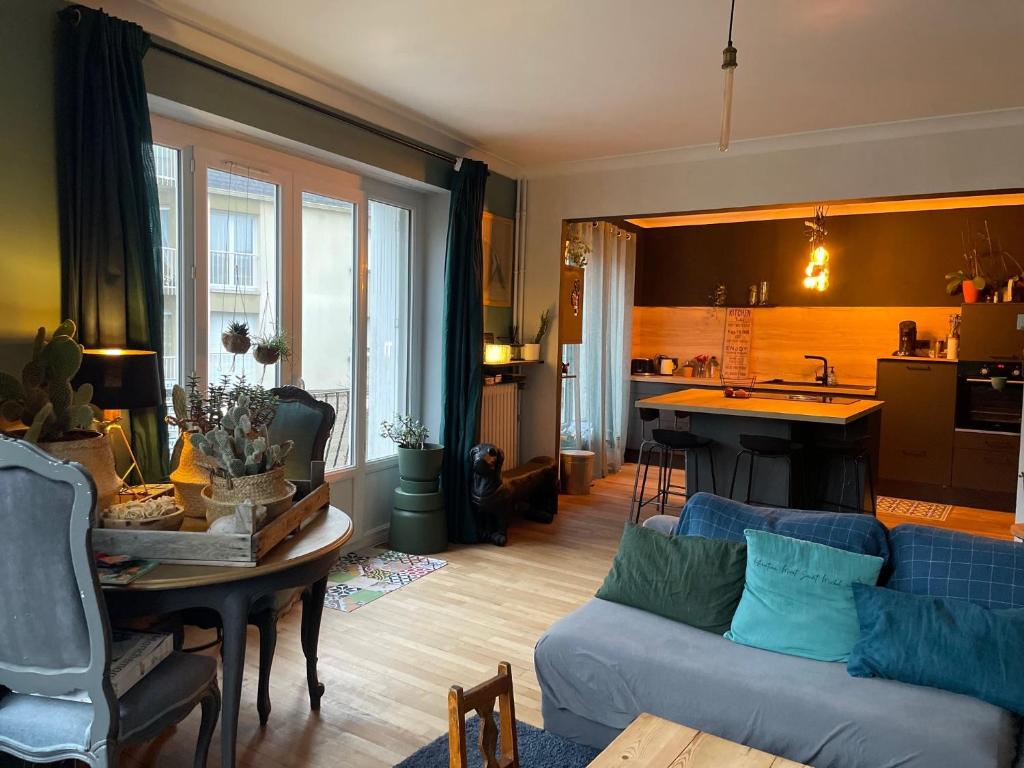 un salon avec un canapé et une cuisine dans l'établissement Maison de ville dans la baie du Mont Saint Michel, à Avranches