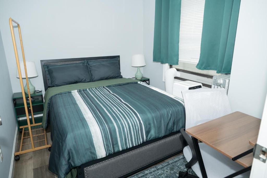 a bedroom with a bed with green sheets and a table at Emerald2 Room at Brighton Beach 2Min Walk to Ocean & Subway Chic Stay in Brooklyn