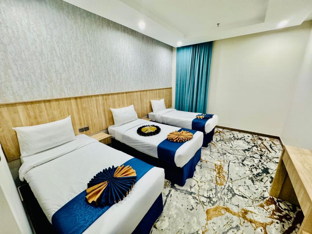 una stanza con due letti in una stanza con un muro rotto di فندق ضيافة منى المشاعر الفندقية a Al Khansāk