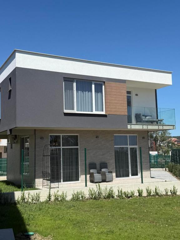 a house with two chairs on the balcony at Aurum Villas Smokinya Beach in Sozopol