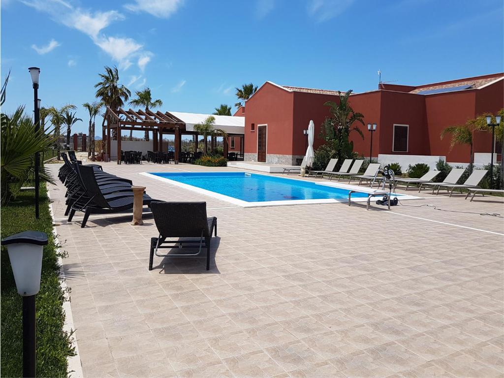een patio met stoelen en een zwembad bij L'Isola del Sale in Trapani