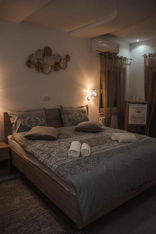 a bedroom with a large bed with two slippers on it at Motel Ječmište in Tuzla