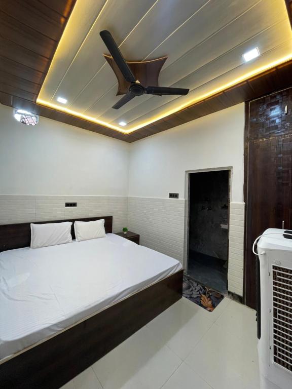 a bedroom with a bed and a ceiling fan at light Inn pg home stay in Mathura