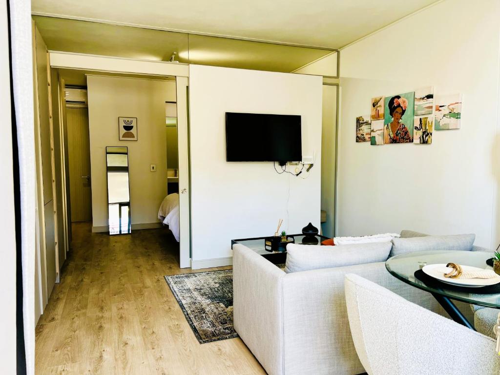 a living room with a couch and a tv on a wall at Urban Luxe Stay - 5 Min to Gautrain & Parking in Johannesburg