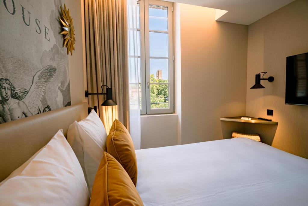 アルビにあるUrban Style Hotel Laperouseの窓のある白いベッドのある寝室