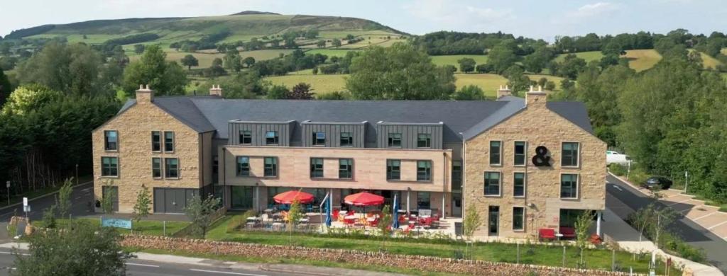 a large house with red umbrellas in front of it at Bike & Boot Inns Peak District - Leisure Hotels for Now in Castleton