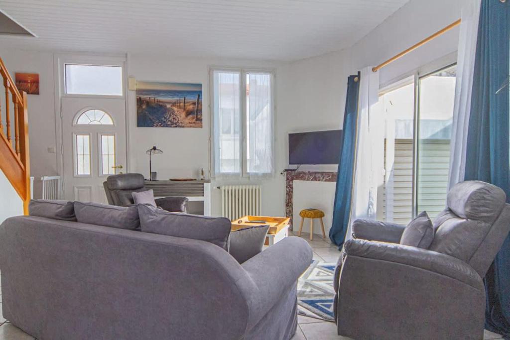 un salon avec deux canapés et un salon avec une cheminée dans l'établissement Jolie maison de ville La Rochelle, à La Rochelle