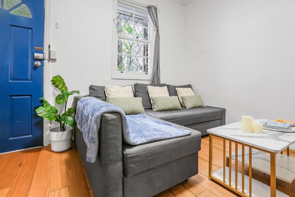 a living room with a gray couch and a table at 2 Bedroom House Darling Harbour Good for 6 Guests in Sydney