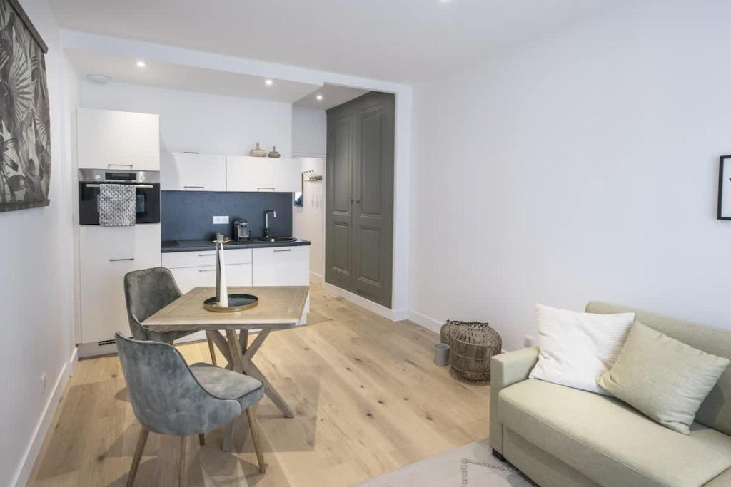 een keuken en woonkamer met een tafel en een bank bij Bel appartement à 2 pas du vieux port in La Rochelle