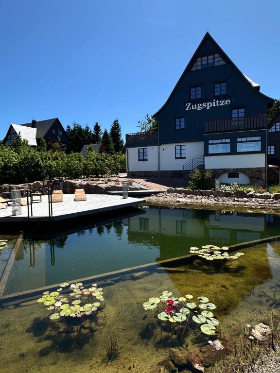 a building with a pool of water with flowers in it at Zugspitze Apartment Weit.Blick in Kurort Altenberg