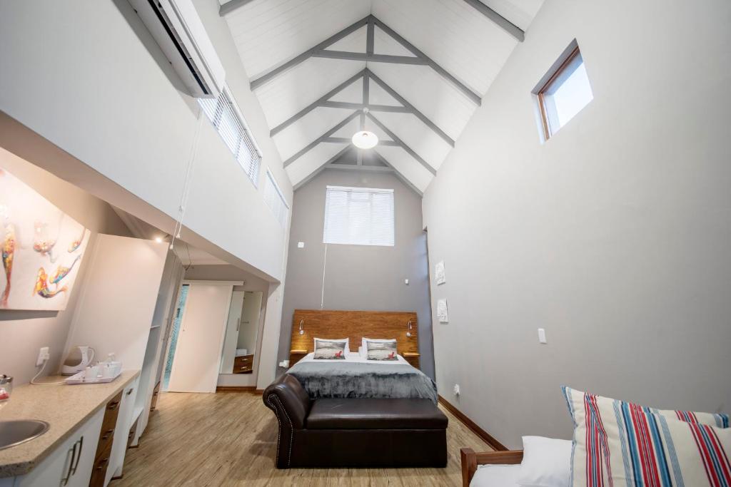 a loft bedroom with a bed and a table at Crisp Guest Rooms in Bloemfontein