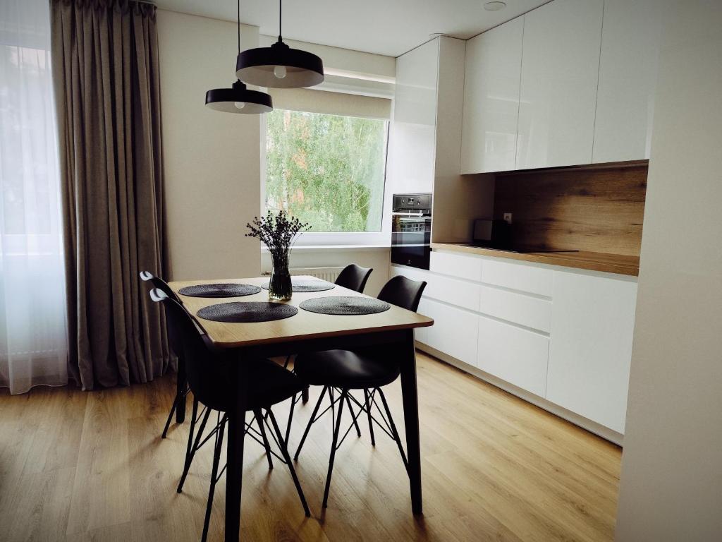 a kitchen with a table and chairs in a room at Stay Rokiškis apartments in Rokiškis