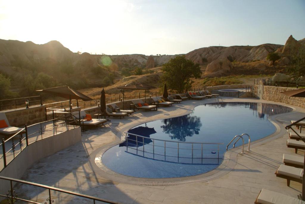 a large swimming pool in a resort with mountains at MDC Cave Hotel Cappadocia in Urgup