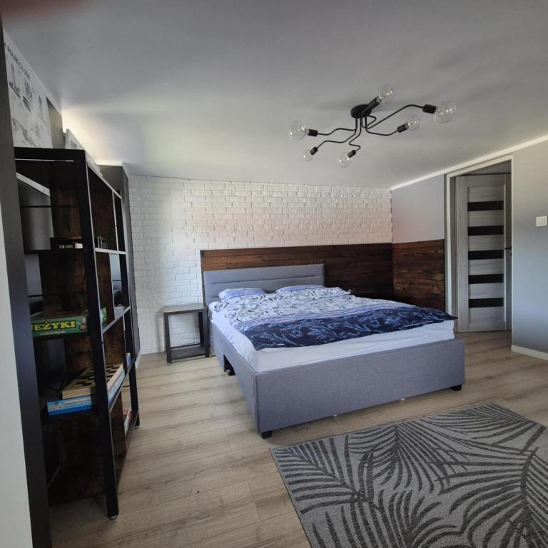 a bedroom with a bed and a book shelf at Sowi Przystanek in Pieszyce