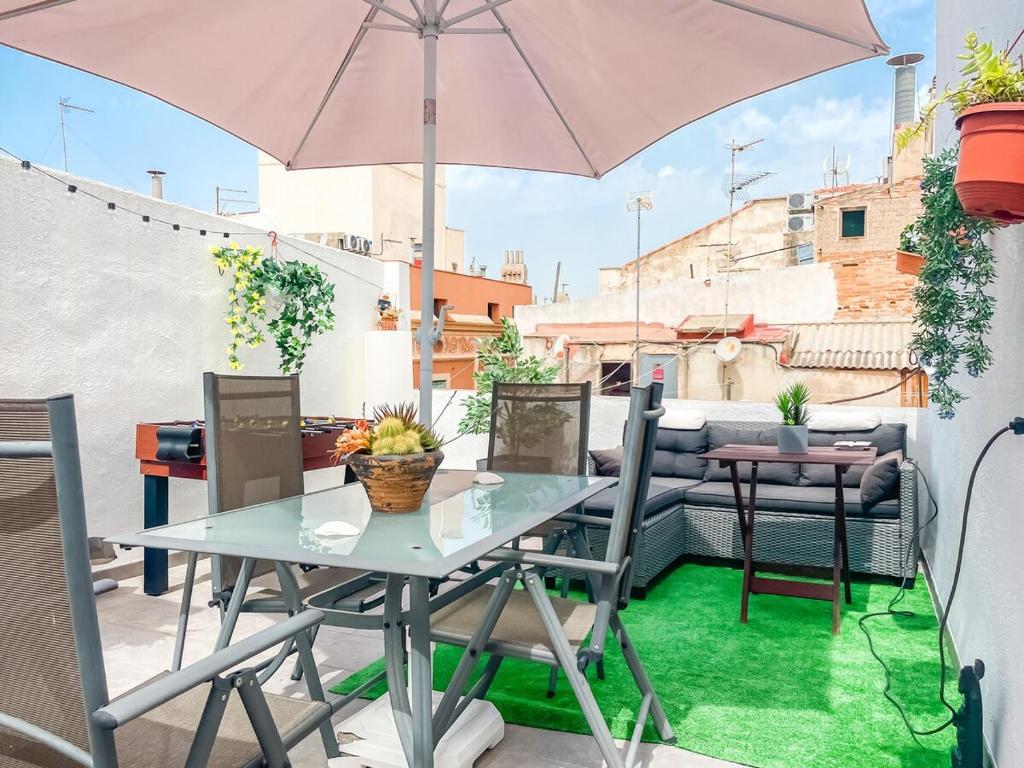 a table and chairs on a patio with an umbrella at Major by Unik Vacation in Tarragona