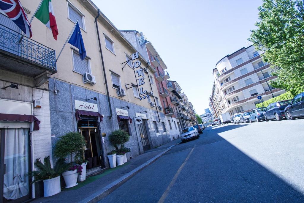 une rue avec un bâtiment et une voiture garée dans la rue dans l'établissement Hotel Adriano, à Turin