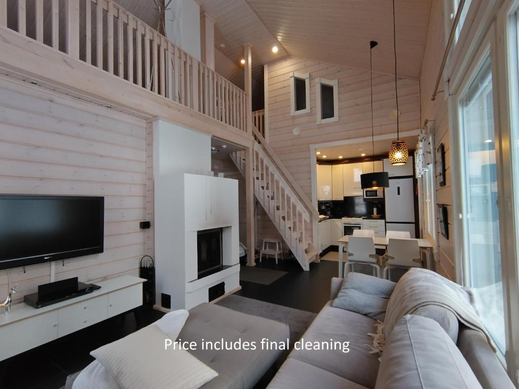a living room with a couch and a tv at Aihki Pine Cottage, Iso-Syöte in Syöte