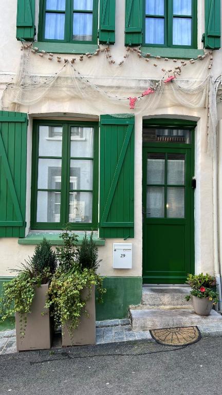 a green door and windows on a building at Ptit Somme en Baie in Saint-Valéry-sur-Somme