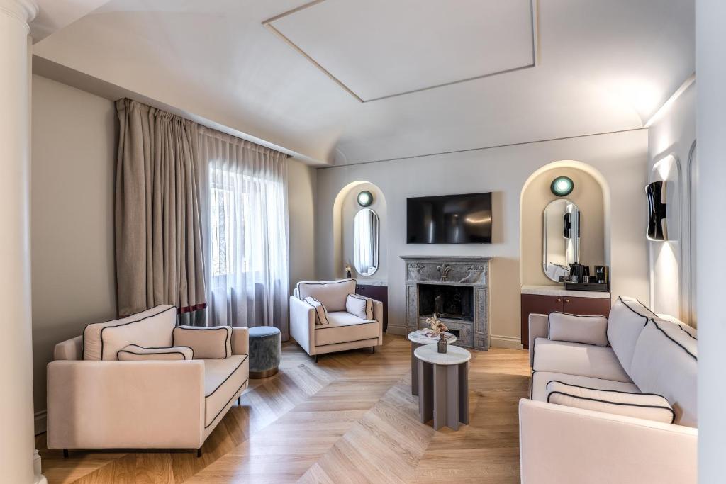 a living room with white furniture and a fireplace at Dimora Coppelle - Adults Only in Rome