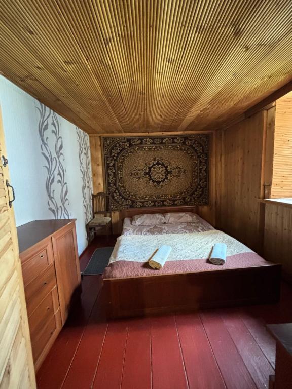 una camera da letto con un letto con soffitto in legno di Old House a Ushguli