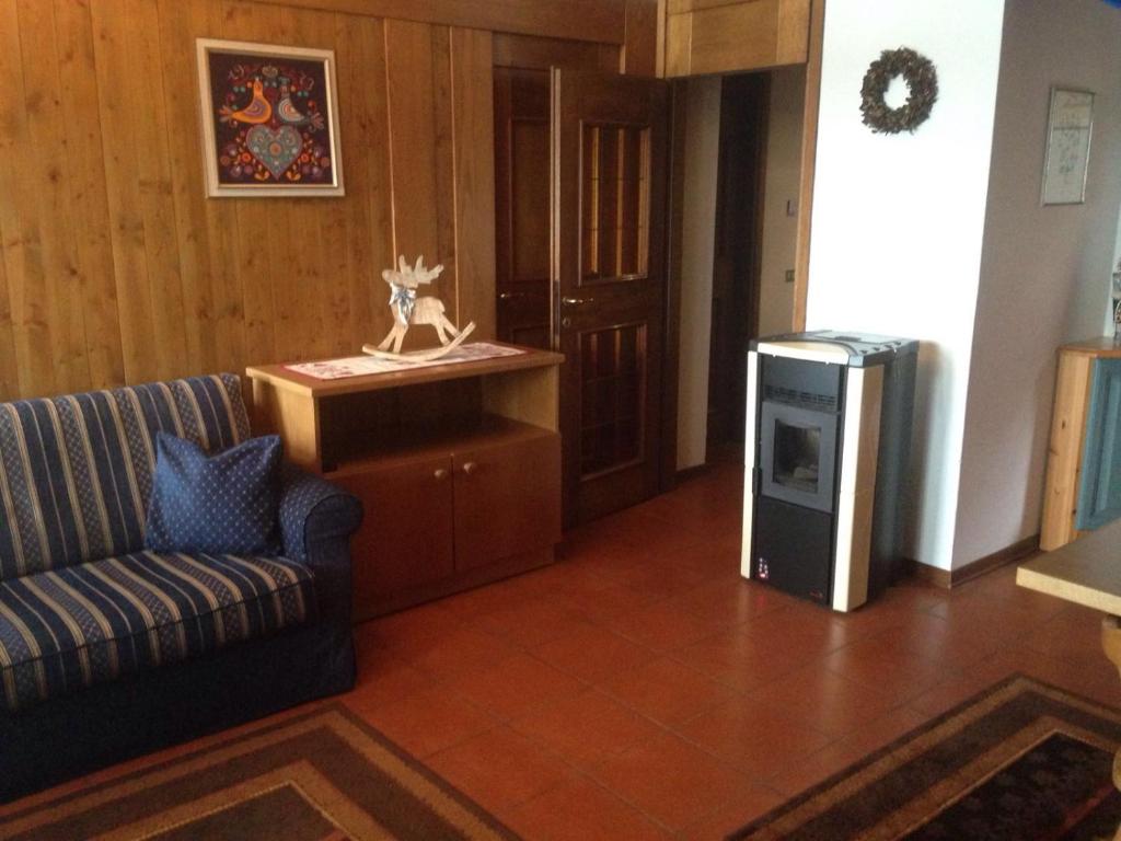 a living room with a couch and a television at Villa San Martino in San Martino di Castrozza