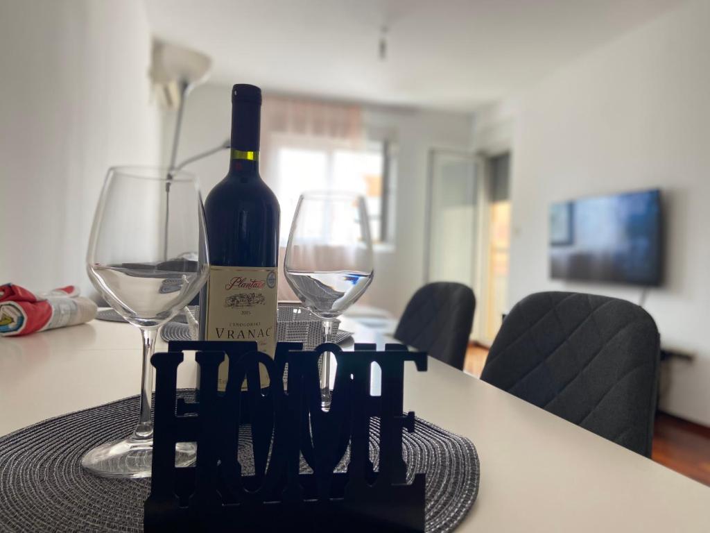 a bottle of wine and two glasses on a table at One bedroom apartment Podgorica in Podgorica