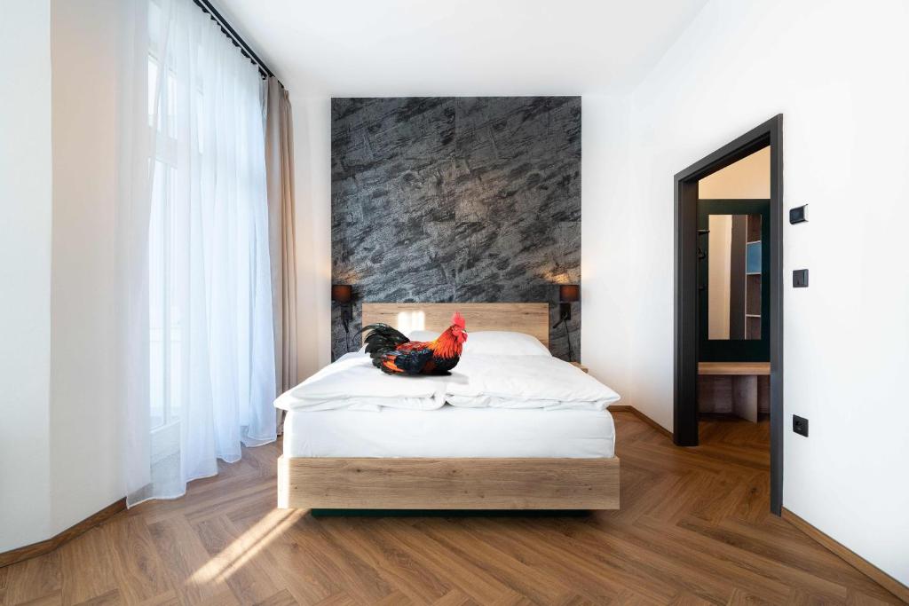 a bedroom with a bed with a chicken sitting on it at OldCock Castle in Znojmo