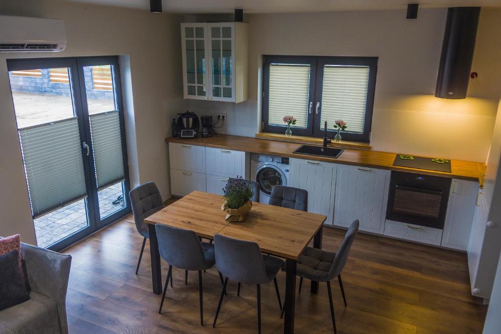 Una cocina con una mesa y sillas de madera. en Apartamenty na Ziołowej, en Pogorzelica