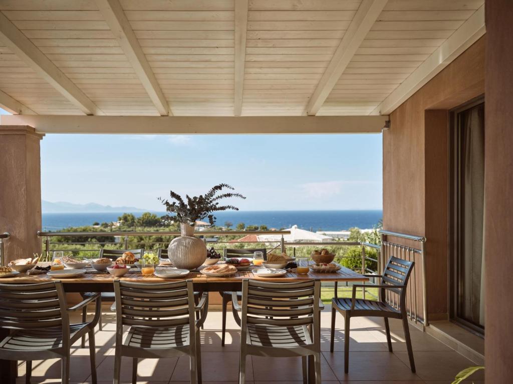 a dining room with a table and chairs on a balcony at Villa Merovigli - Sea Views & Private Pool, Ideal for Large Groups, by ZanteWize in Tragaki