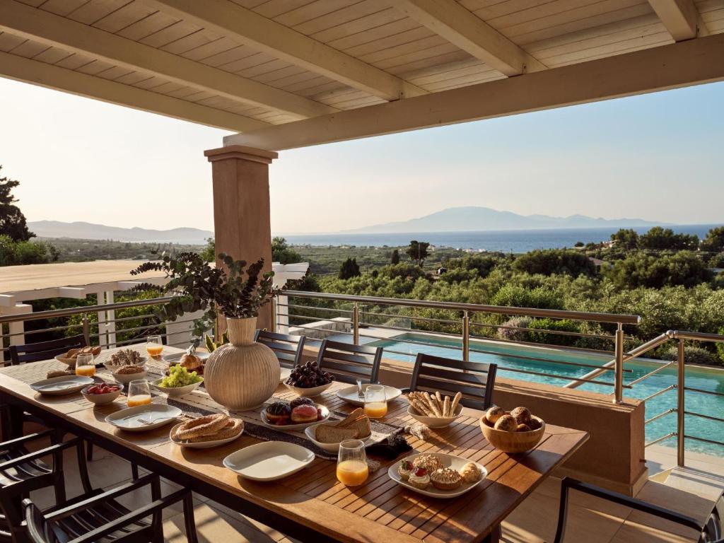 トラガキにあるVilla Merovigli - Sea Views & Private Pool, Ideal for Large Groups, by ZanteWizeのプール付きのバルコニーの上にテーブルと食べ物