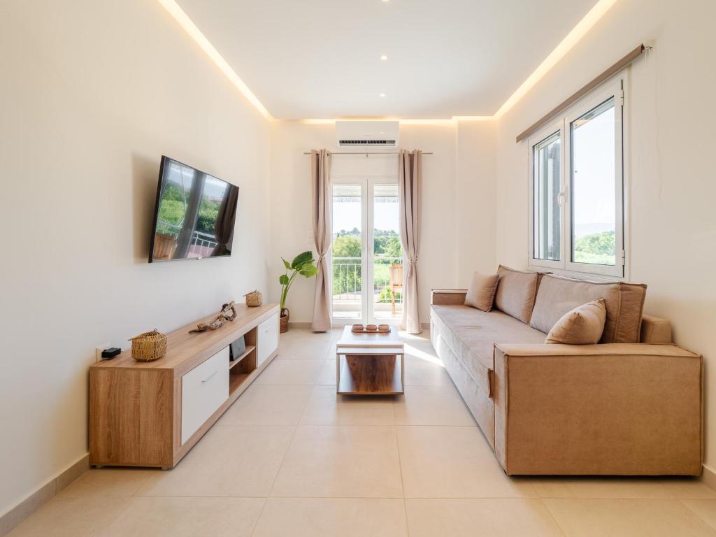 a living room with a couch and a tv at Terra Residence in Ágios Rókkos