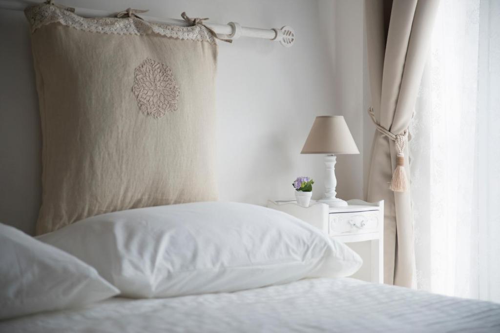 リド・ディ・オスティアにあるTisserand Boutique & Apartmentのベッド(白いシーツ、ランプ、窓付)