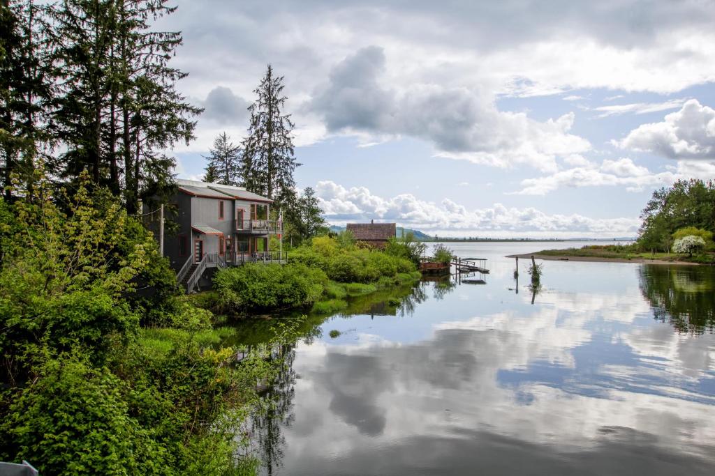 Un río con casas y árboles al lado de un cuerpo de agua. en Peaceful Waterfront Escape In Skamokawa, en Skamokawa