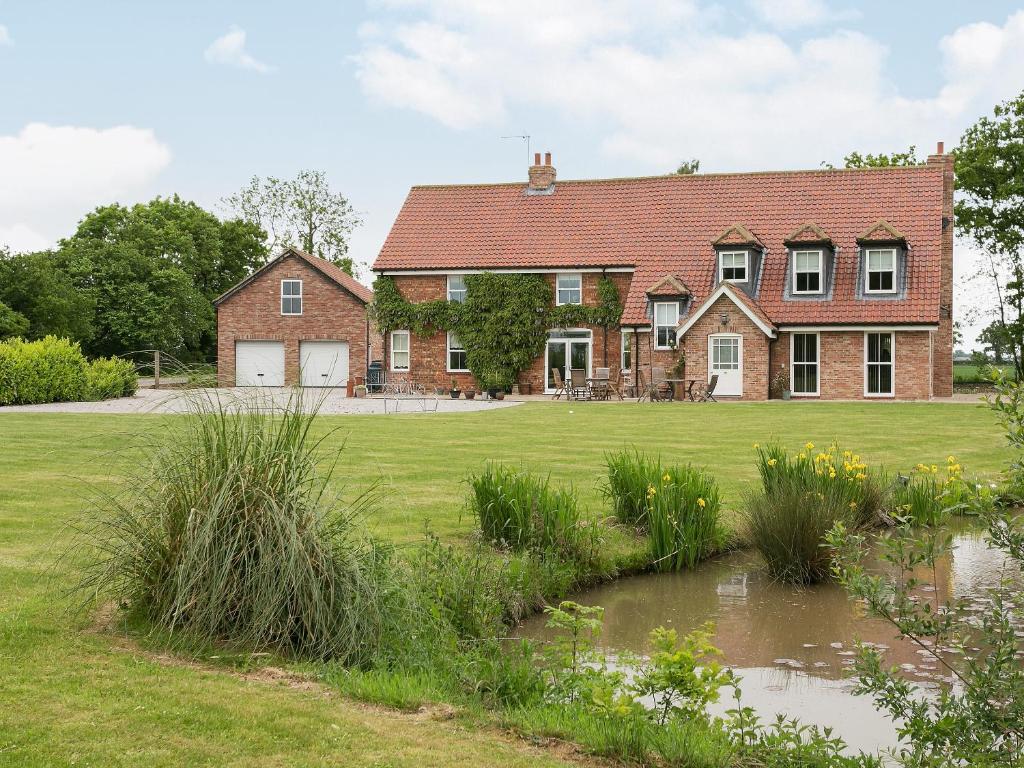 una casa con un laghetto davanti di Yokefleet Cottage a Sandholme