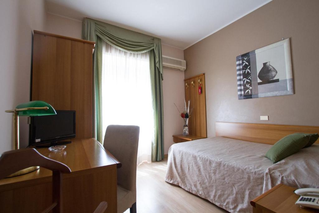 Postel nebo postele na pokoji v ubytování Hotel Adriano