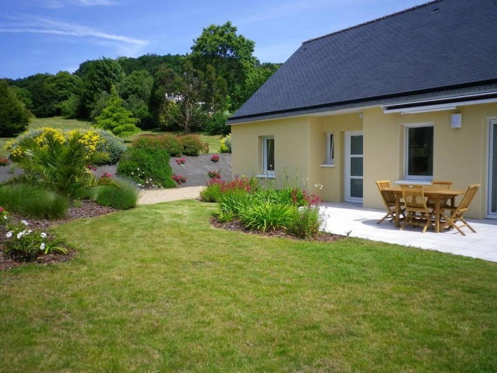 a house with a patio and a table in the yard at Les jardins de kerarzic in Ploubazlanec