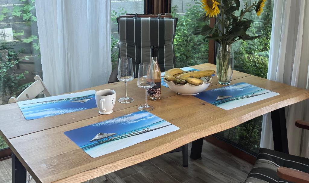 a wooden table with wine glasses and a bowl of bananas at Casa M in Kranevo