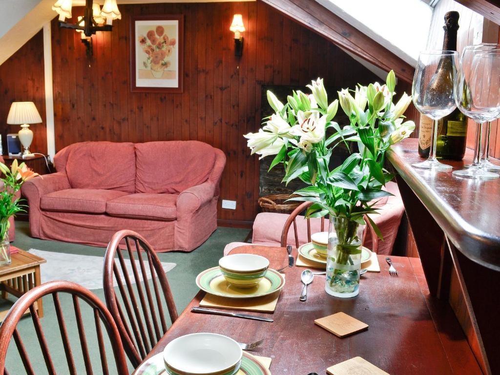 a living room with a table with flowers and a couch at Cider House in Launceston