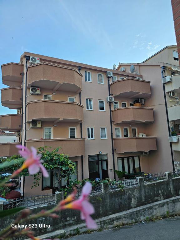 two pink birds flying in front of a building at Apartmani Alexandra in Budva